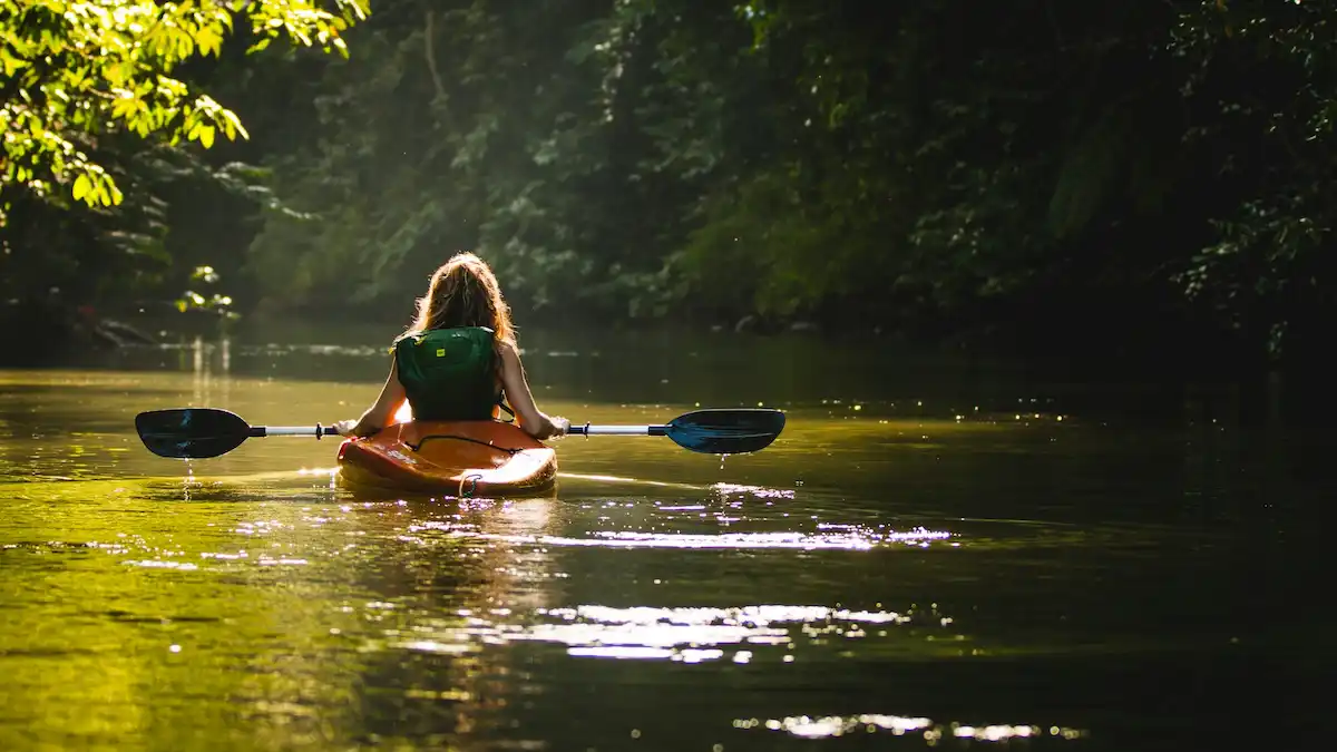 child canoeing on a slow moving river