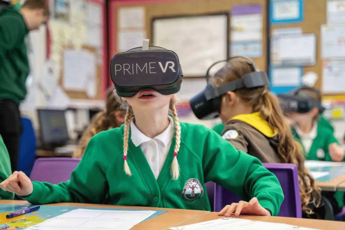 three children in a classroom with VR headsets