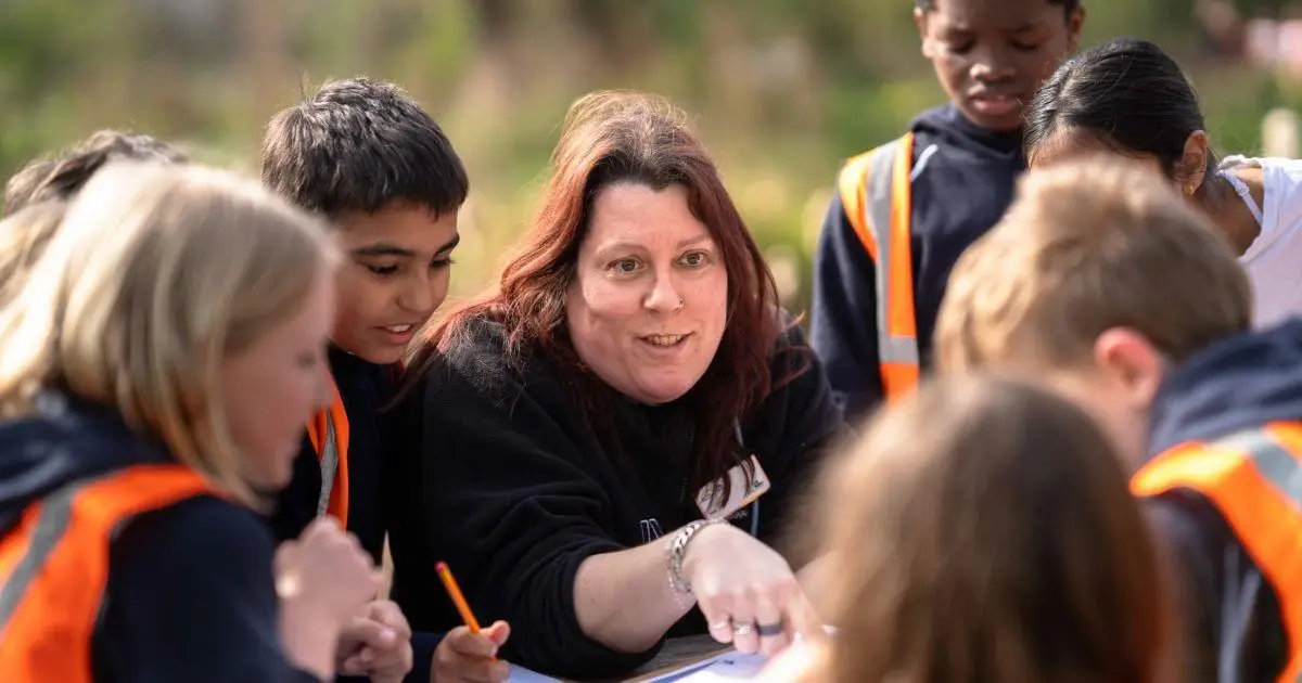 KS1 child with a magnifying glass on a bug hunt