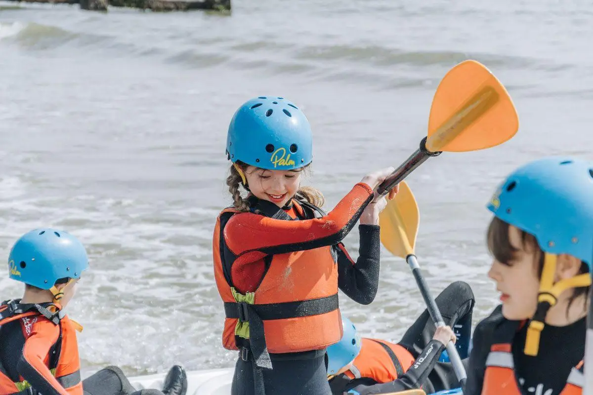 school group in wet suits with body boards by the sea in Dorset