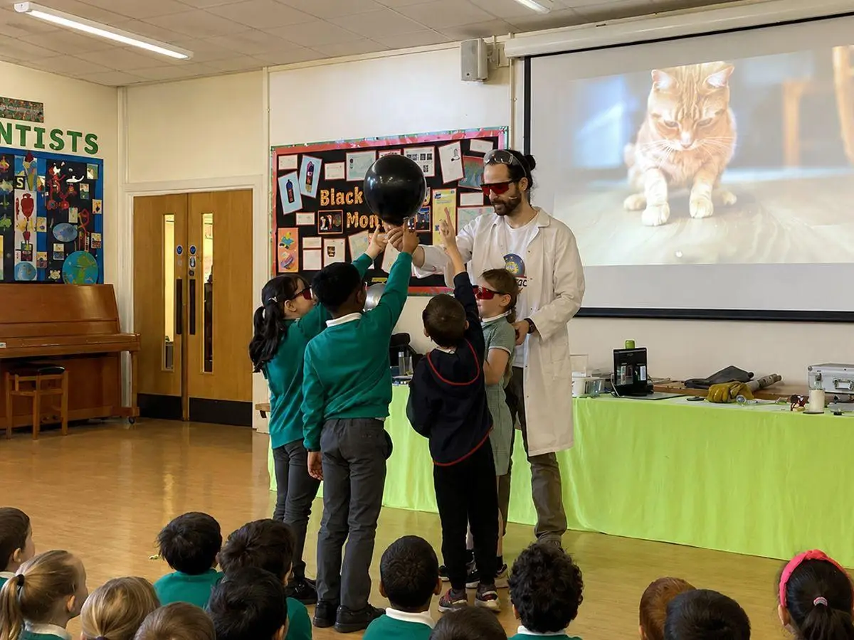 actor holding a globe during a british science week school workshop