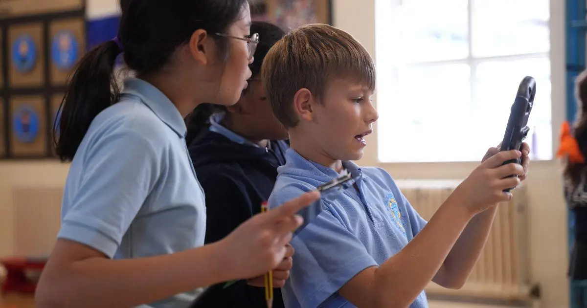 children in school hall playing an augmented reality ancient greeks history game